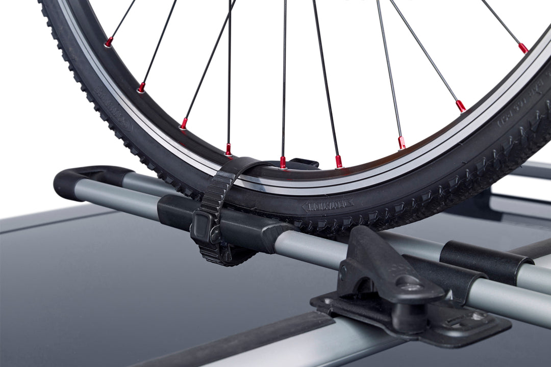 A close-up showing a bike wheel secured into the Thule FreeRide using the wheel strap