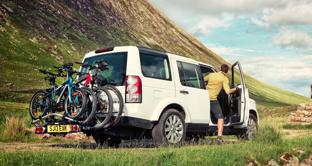 The Thule Velocompact with 4 bikes loaded for family adventures in a land Rover